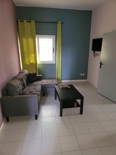 uma sala de estar com um sofá e uma mesa de centro em RESIDENCE BELIER KEUR MOUSSA 