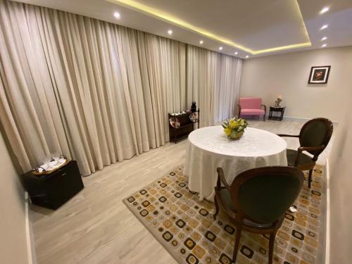 a room with a white table and chairs and a room with curtains at Pousada Granja Santa Barbara in Petrópolis