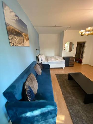 a living room with a blue couch and a bed at apartment with balcony in Berlin
