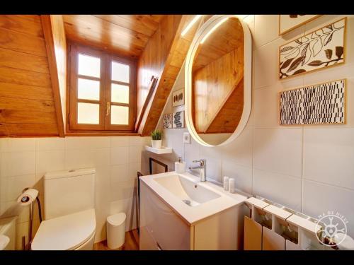 a bathroom with a sink and a toilet and a mirror at CASA DEL VALLE de Alma de Nieve in Tredós