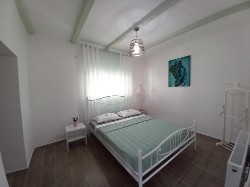a white bedroom with a bed and a window at Guest house of gnomes in Akhmety