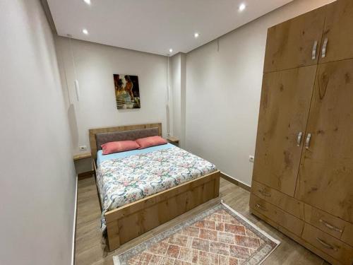 Un dormitorio pequeño con una cama y una cómoda. en Modern 1 Bedroom City Apartment, en Tirana