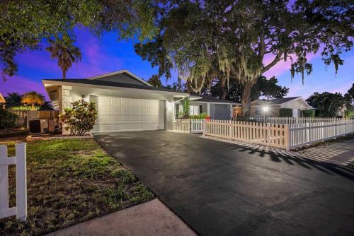 a house with a white fence and a driveway at Heated Pool House: Beach 3Miles · Bar · BBQ & GYM! in Largo