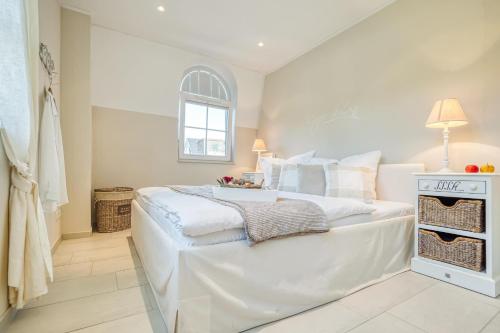 Un dormitorio blanco con una cama grande y una ventana en Strandappartement Wieck Nr 4, en Zingst