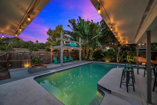 a swimming pool in a backyard with a table and chairs at Heated Pool House: Beach 3Miles · Bar · BBQ & GYM! in Largo