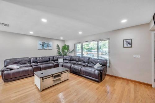 a living room with a leather couch and a table at Heated Pool House: Beach 3Miles · Bar · BBQ & GYM! in Largo