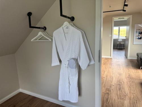 a white robe hanging on a wall in a room at Urriðafoss Waterfall Villa in Selfoss