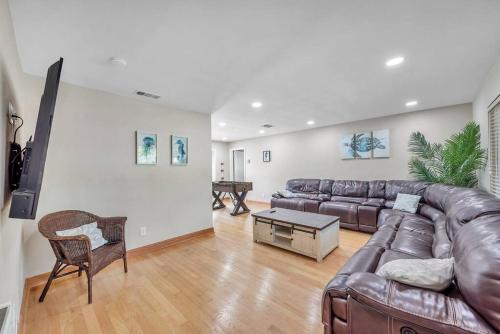 a living room with a leather couch and a table at Heated Pool House: Beach 3Miles · Bar · BBQ & GYM! in Largo