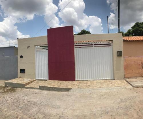 eine Garage mit zwei weißen und roten Türen in der Unterkunft Casa aconchego in Canindé de São Francisco