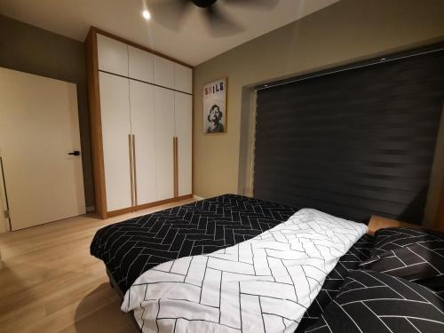 um quarto com uma cama com um edredão preto e branco em Melaka Homestay Best in Town 6+3 paxs em Malaca