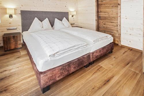1 cama grande en un dormitorio con suelo de madera en Kendlalm en Saalbach Hinterglemm