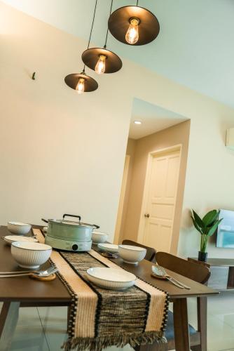 a dining room table with bowls and plates on it at Cosy City-View Suite in Town in Ipoh