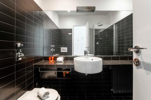 a bathroom with a sink and a toilet and a mirror at LUVI - Duomo in Milan