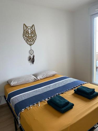 - un lit avec 2 oreillers et une horloge murale dans l'établissement T2 au pieds du métro, la soie, à Villeurbanne