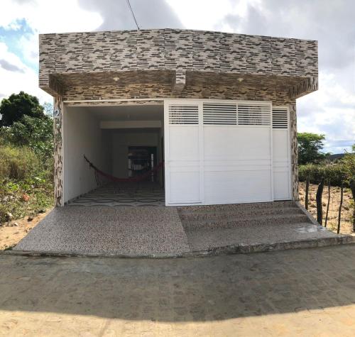 a garage with a white door and a fence at P nacional do catimbau Buíque de 1 a 10 hospeder in Catimbau