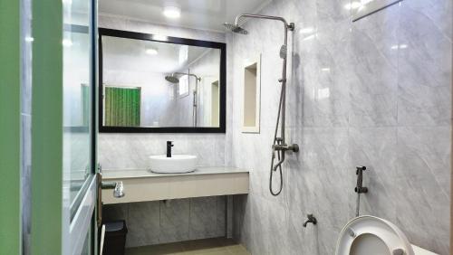 bagno con lavandino e doccia con specchio di Isle Inn Guesthouse a Fuvahmulah