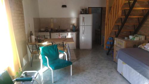 a kitchen with a table and chairs and a refrigerator at Malula Departamentos. in Playas Doradas
