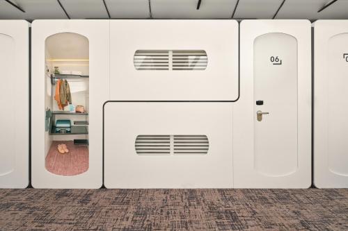 a row of white garage doors in a room at CityHub Amsterdam in Amsterdam