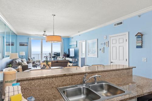 a kitchen with a sink and a living room at Twin Palms Beach Resort by Panhandle Getaways in Panama City Beach