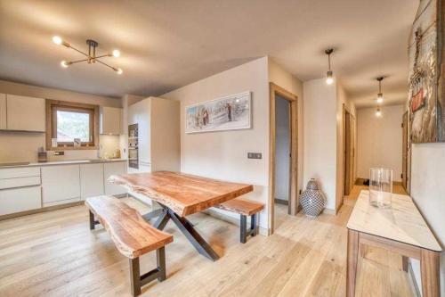 eine Küche und ein Esszimmer mit einem Holztisch in der Unterkunft High standing 6P3BR apartment - Résidence Stallion Megève in Megève
