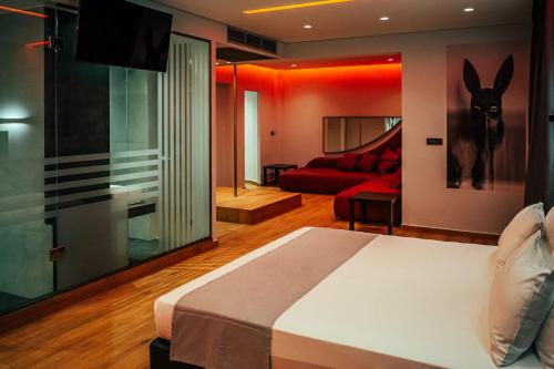 雅典的住宿－派內斯酒店，一间卧室配有一张床和一张红色的沙发