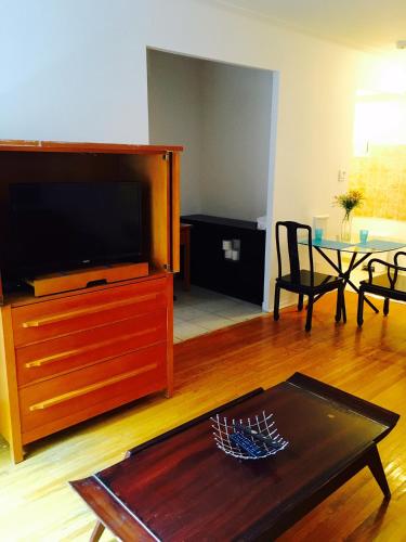 - un salon avec une télévision et une table basse dans l'établissement Stylish Montreal Apartment: Comfortable Stay in the Golden Square Mile, à Montréal