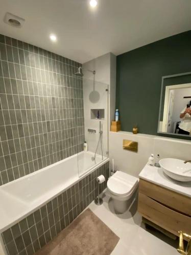 a bathroom with a toilet and a tub and a sink at Calming 1BD Oasis by River Thames - Rotherhithe in London