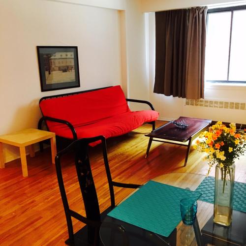 a living room with a red couch and a table at Stylish Montreal Apartment: Comfortable Stay in the Golden Square Mile in Montreal