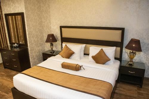 a bedroom with a large bed with two night stands at Centaurus Hotel Suites in Islamabad