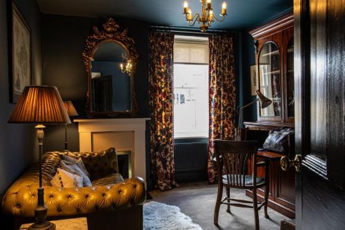 a living room with a couch and a mirror and a chair at The Townhouse Sherborne in Sherborne