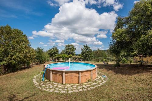 a circular pool in a yard with trees and a sky at Lavanda in Montieri