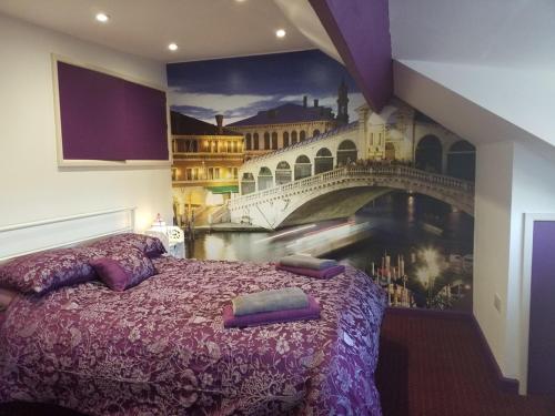 a bedroom with a bed with a painting of a bridge at No 3 Lingdale - 4 bedroom house close to N Yorks Moors in Boosbeck