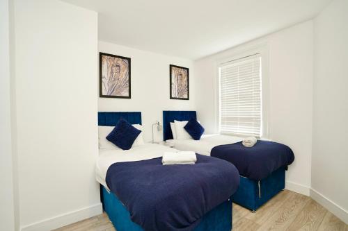 a bedroom with two beds and a window at Huntingdon Luxury Apartments in Huntingdon