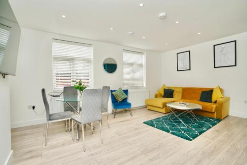 a living room with a yellow couch and a table at Huntingdon Luxury Apartments in Huntingdon