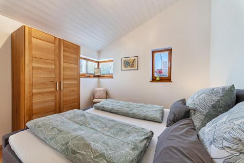 Naturnahe Ferienwohnung Deuerling في Deuerling: غرفة نوم بسريرين وخزانة خشبية