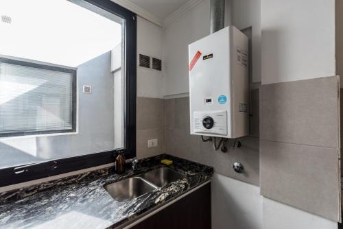 eine kleine Küche mit einem Waschbecken und einem Fenster in der Unterkunft Independencia Nva Cba para 6 personas in Cordoba