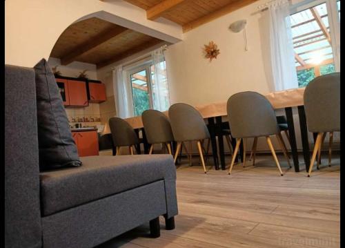 uma sala de estar com uma mesa de jantar e cadeiras em Kristóf kulcsosház em Gheorgheni