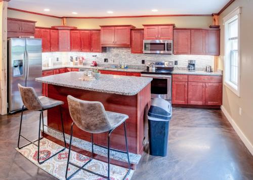 a kitchen with red cabinets and a island with bar stools at House close to Acadia National Park in Ellsworth