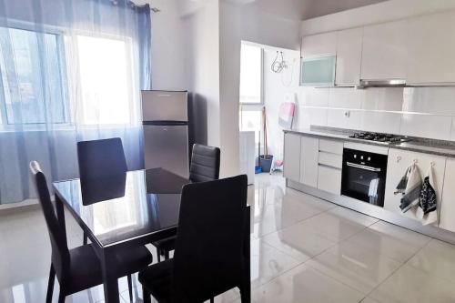 y cocina con mesa, sillas y fogones. en Apt Plateau, en Praia