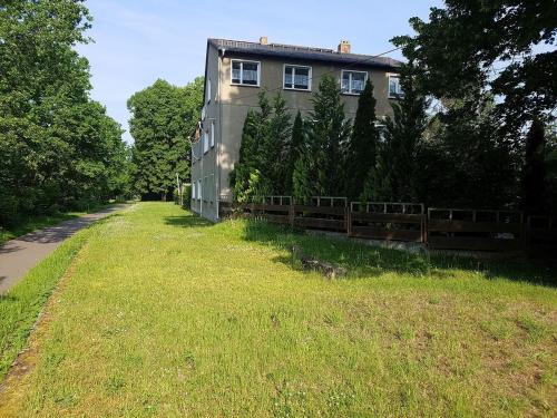 a house with a fence next to a grass field at Ferienwohnung am Thüringen Radweg in Rauda