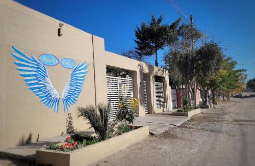 a building with a painting of wings on the side of it at Alquileres Grutenses in Las Grutas