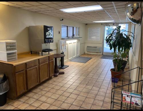 a waiting room with a counter and a table in a room at Economy Inn of Greenville, Near ECU Health Center in Greenville