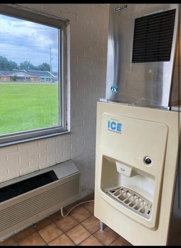 una macchina del ghiaccio in una stanza con finestra di Economy Inn of Greenville, Near ECU Health Center a Greenville