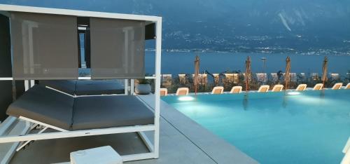 Habitación con piscina, mesa y sillas en Hotel Mercedes, en Limone sul Garda