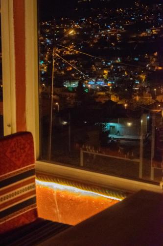 a window with a view of a city at night at Twilight Hotel Petra in Wadi Musa