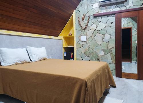 a bedroom with a bed and a stone wall at Recanto Alto da Serra in Portalegre