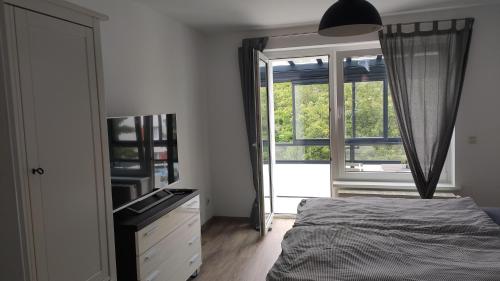 um quarto com uma cama, uma cómoda e uma janela em Wohnung Meeresbrise 48 qm mit Balkon em Rostock
