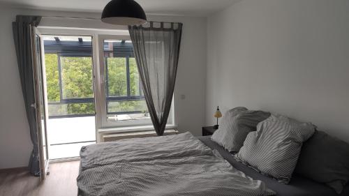 1 dormitorio con cama y ventana grande en Wohnung Meeresbrise 48 qm mit Balkon, en Rostock