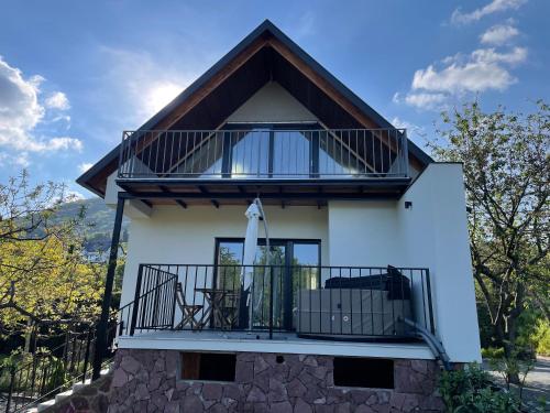 a white house with a balcony on top of it at Rózsakő Ház in Badacsonytomaj