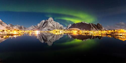 an image of the northern lights over the mountains at Eliassen Rorbuer in Reine